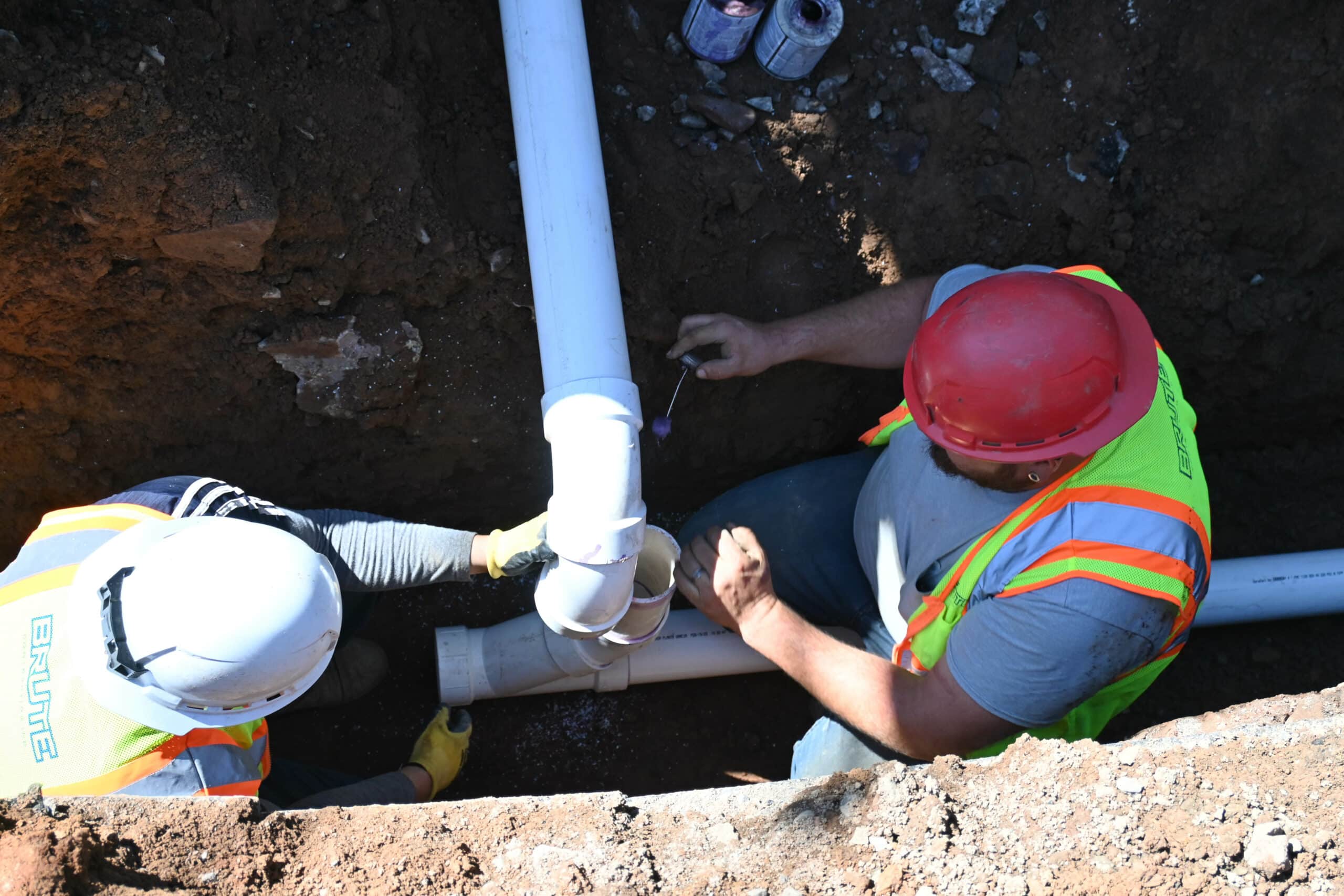 Sewer line repair experts installing a new sewer line into a residential home