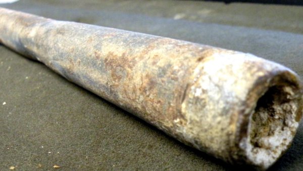 Rusty Salt crusted Metal Pipe Segment Lying on a Dark Surface